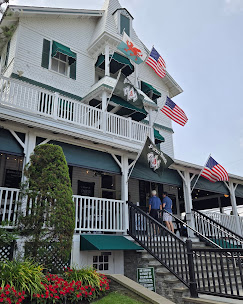 Parker House in Sea Girt, featuring vibrant flags and a welcoming porch, popular for happy hour and live music, reflecting the lively Jersey Shore nightlife scene.