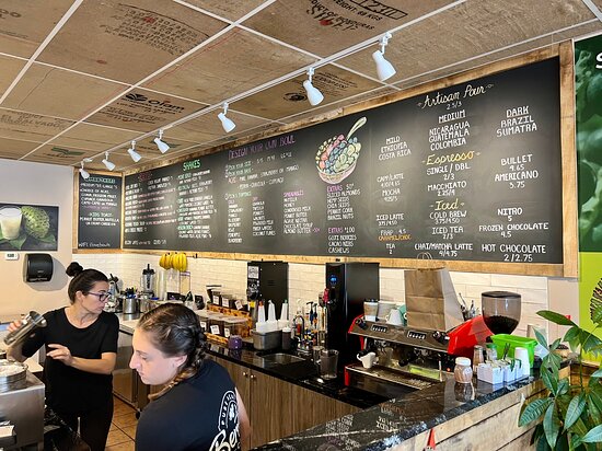 Coffee shop interior with chalkboard menu displaying beverage options, baristas preparing drinks, and a modern, cozy atmosphere, reflecting the vibe of Berritazza Café in Point Pleasant.