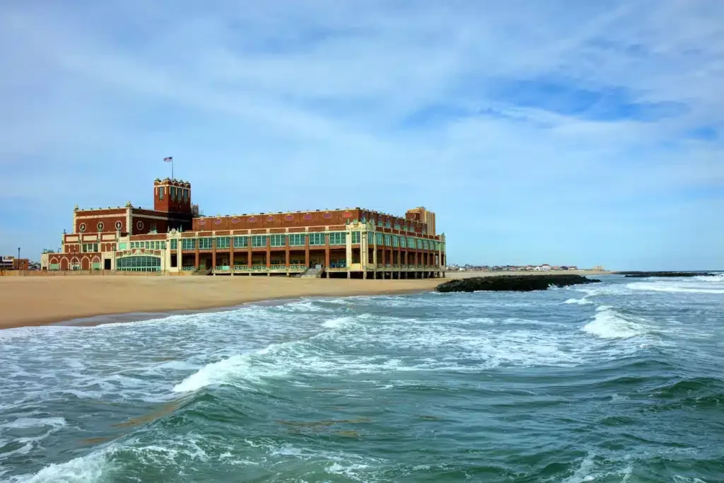 Asbury Park beachfront with historic architecture, waves lapping at the shore, showcasing the vibrant coastal city atmosphere.