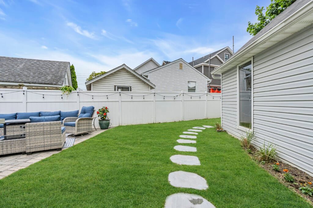 Backyard patio area with a stone pathway and outdoor seating, ideal for relaxation after exploring nearby trails.