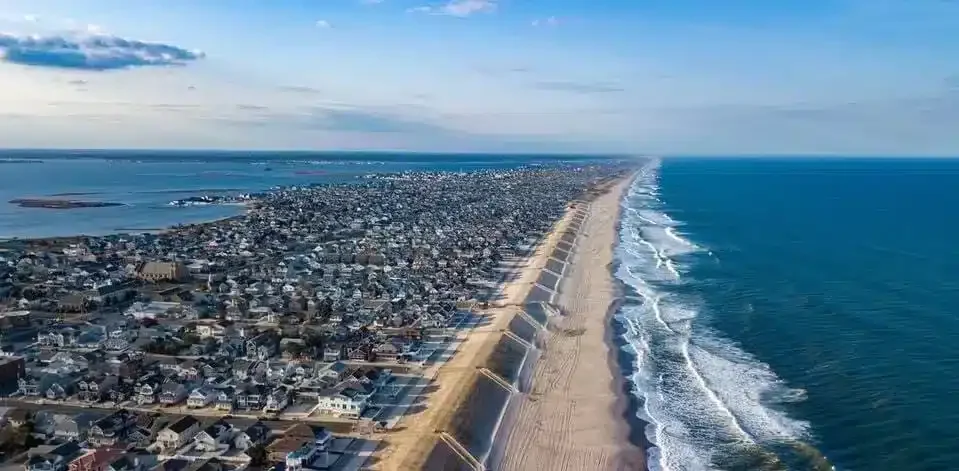 Aerial view of the Jersey Shore coastline featuring sandy beaches, ocean waves, and seaside homes.