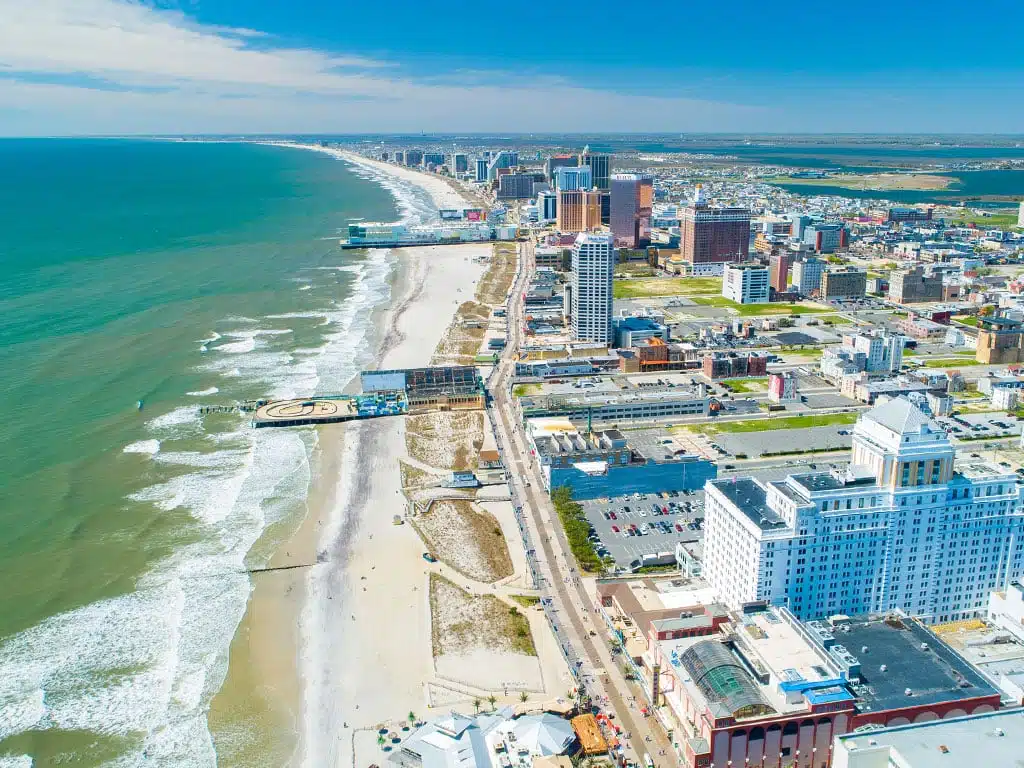 Aerial view of Atlantic City, New Jersey, showcasing the coastline, sandy beach, and city skyline with hotels and attractions, emphasizing the vibrant vacation destination along the Jersey Shore.