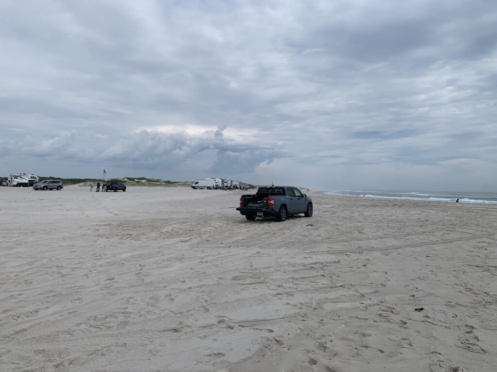 Truck driving on the sandy beach at Island Beach State Park, showcasing a unique Jersey Shore experience for visitors looking to explore the shore.