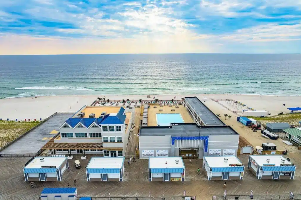 Aerial view of beachfront dining establishments and boardwalk at the Jersey Shore, showcasing ocean views and outdoor seating areas.