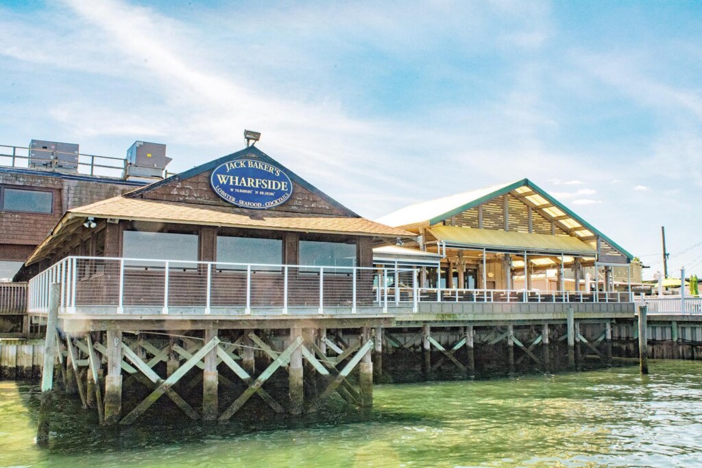 Jack Baker's Wharfside Restaurant exterior, featuring a waterfront view, signage displaying "Jack Baker's Wharfside" with offerings of lobster, seafood, and cocktails, highlighting its upscale dining experience in Point Pleasant Beach.