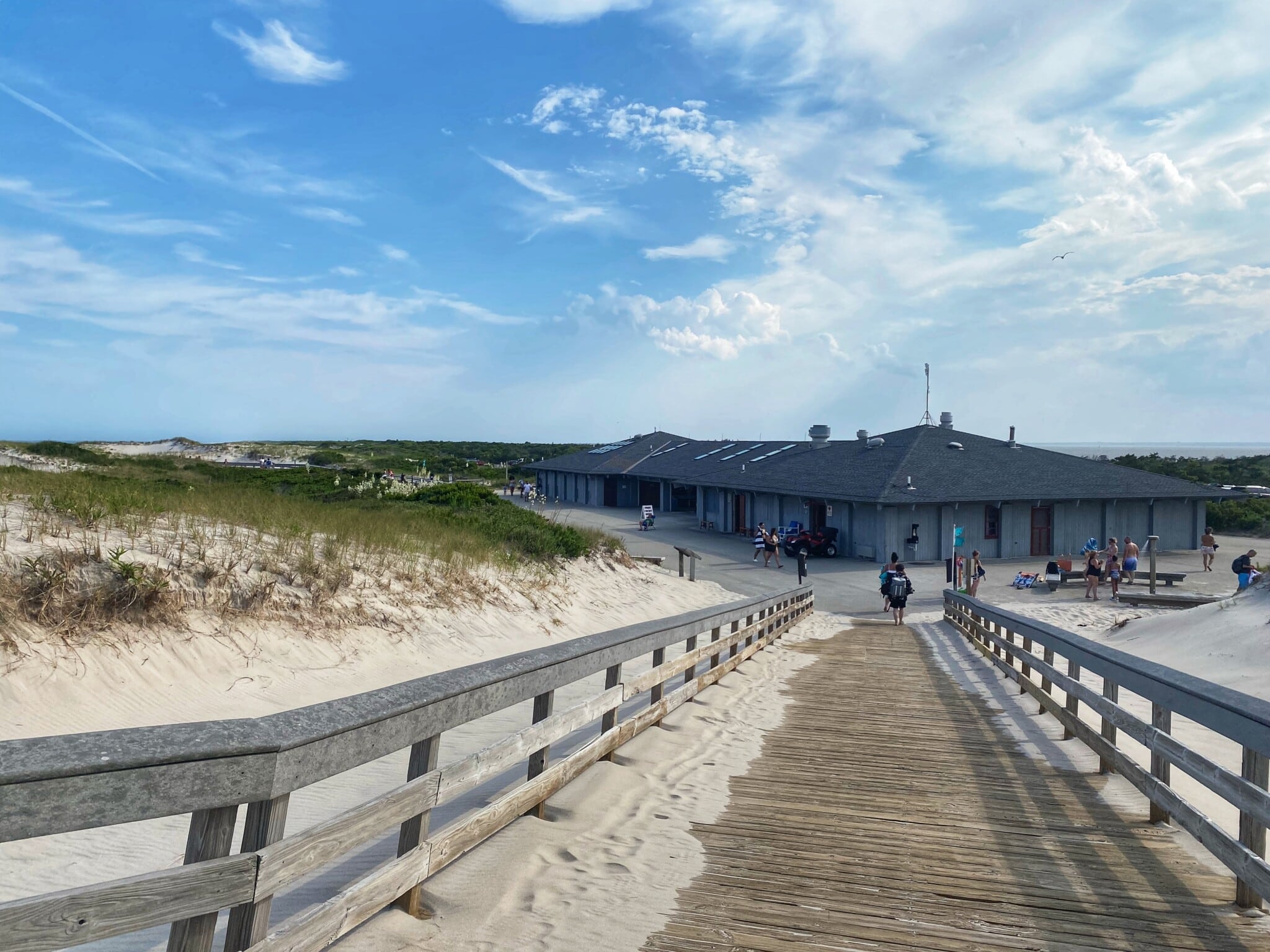 Wooden boardwalk leading to a building nestled amongst sand dunes and maritime forest at Island