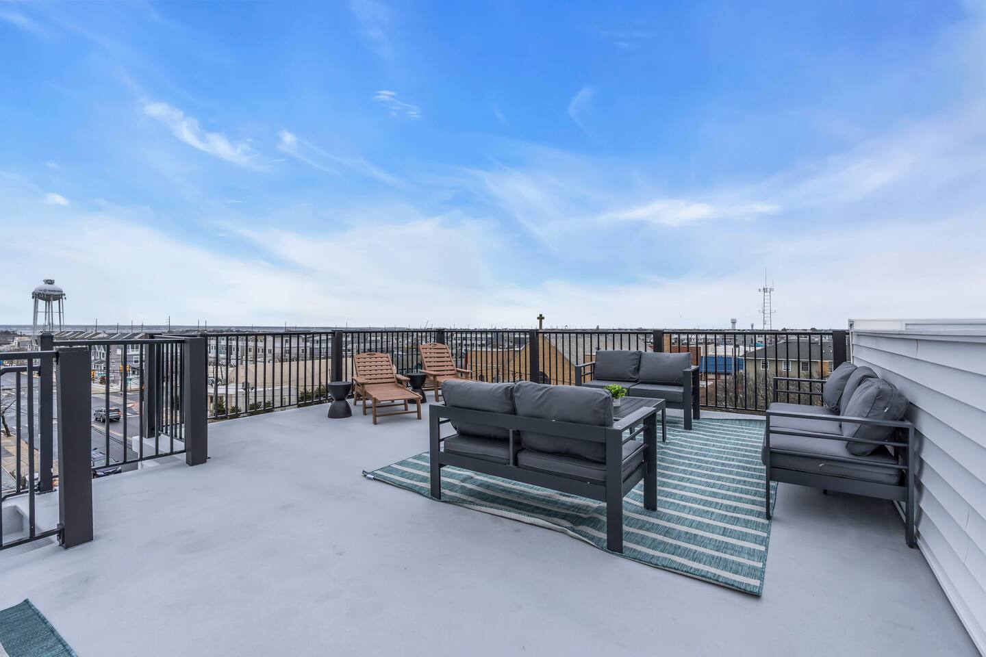 Rooftop deck with seating area, offering ocean and bay views, at new construction short-term rental property in Seaside Heights, NJ.