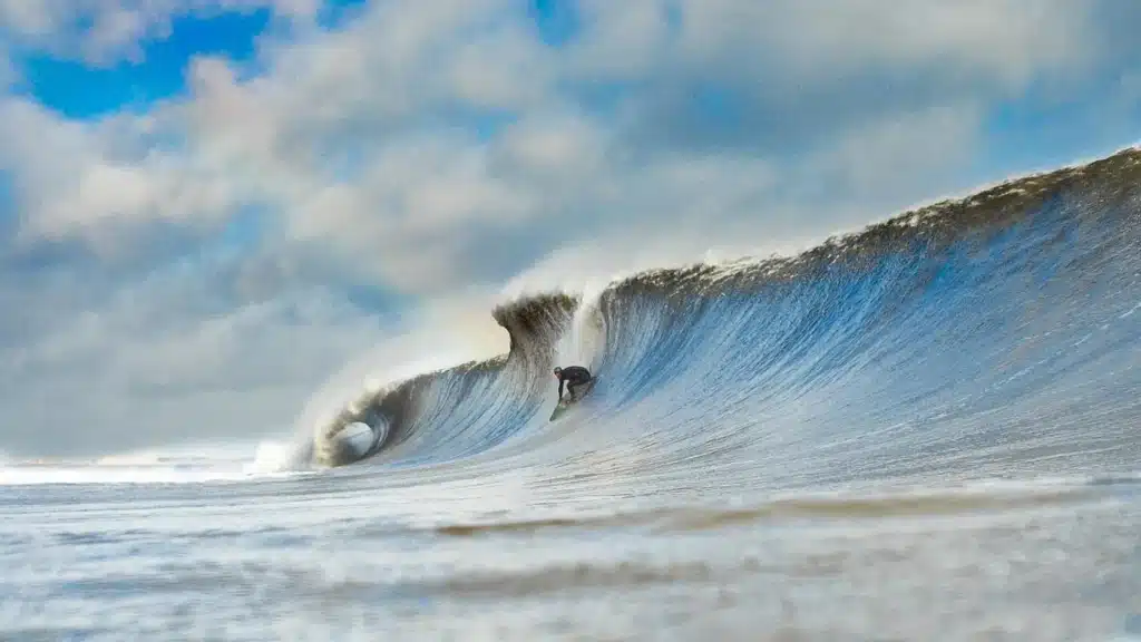 Surfer riding a powerful wave at the Jersey Shore, showcasing the region's excellent beachbreak conditions for surfing.