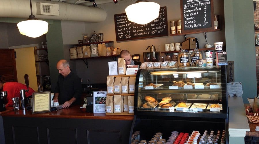 Turnstile Coffee Roasters interior with baristas, coffee equipment, and pastry display, showcasing a cozy atmosphere for enjoying high-quality coffee at the Jersey Shore.