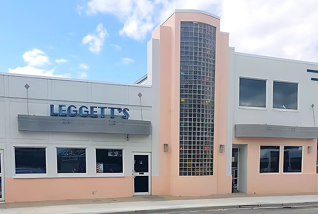 Leggett's Sand Bar exterior featuring a modern design, prominent signage, and glass block wall, located near the Osprey in Manasquan, known for daytime activities and nightlife.