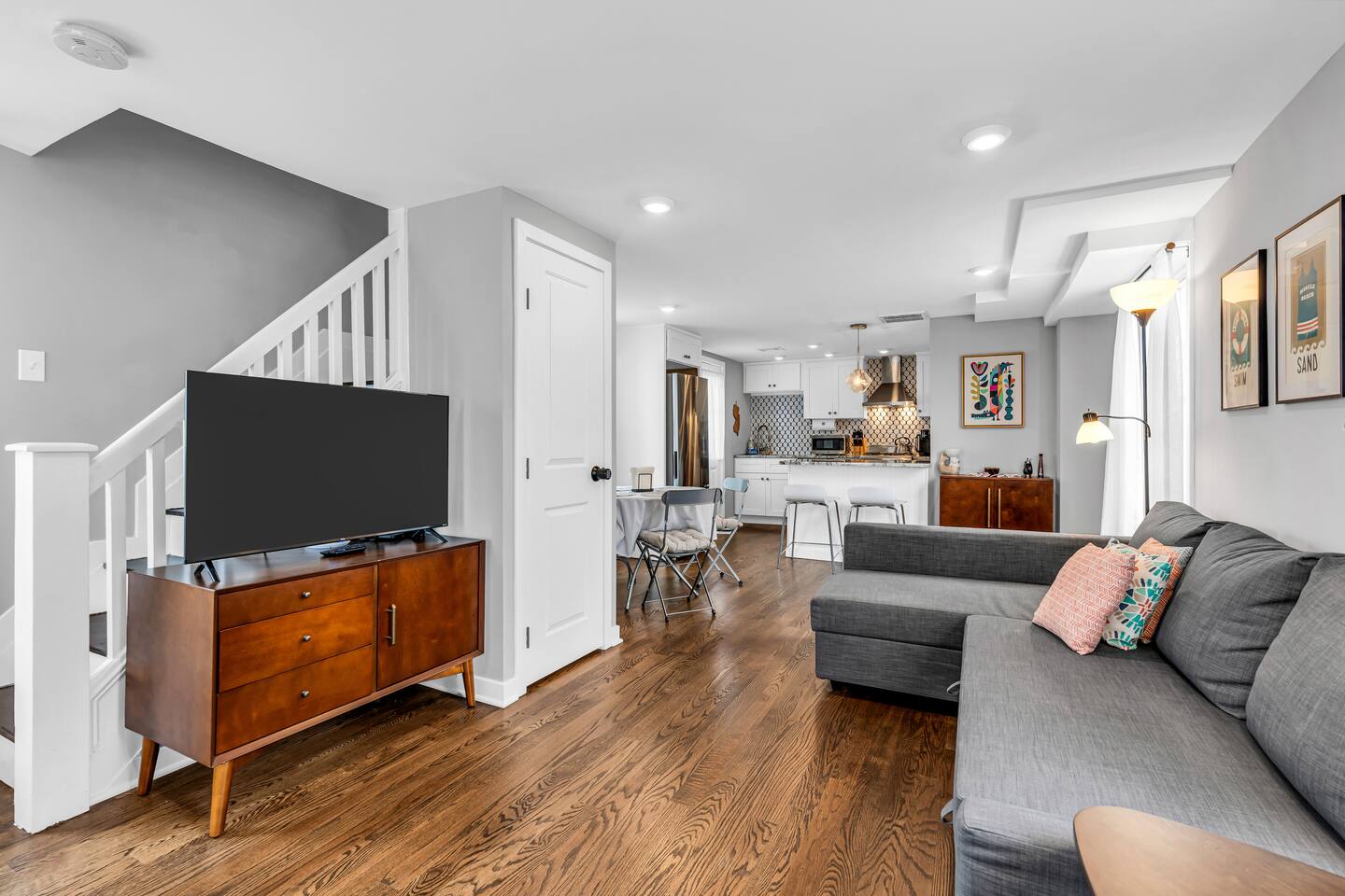 Comfortable Jersey Shore vacation rental living room with sofa, TV, and kitchen amenities.