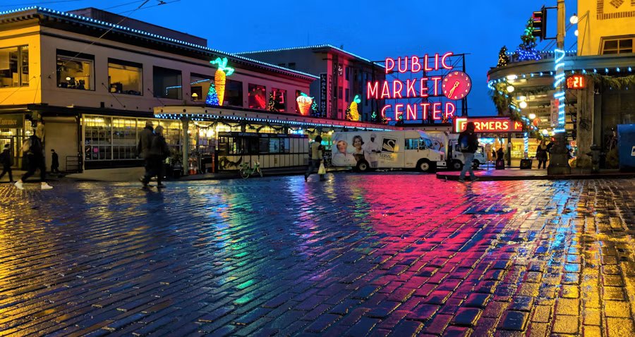 Pike Place Market neon reflected on a wet street at night in Seattle