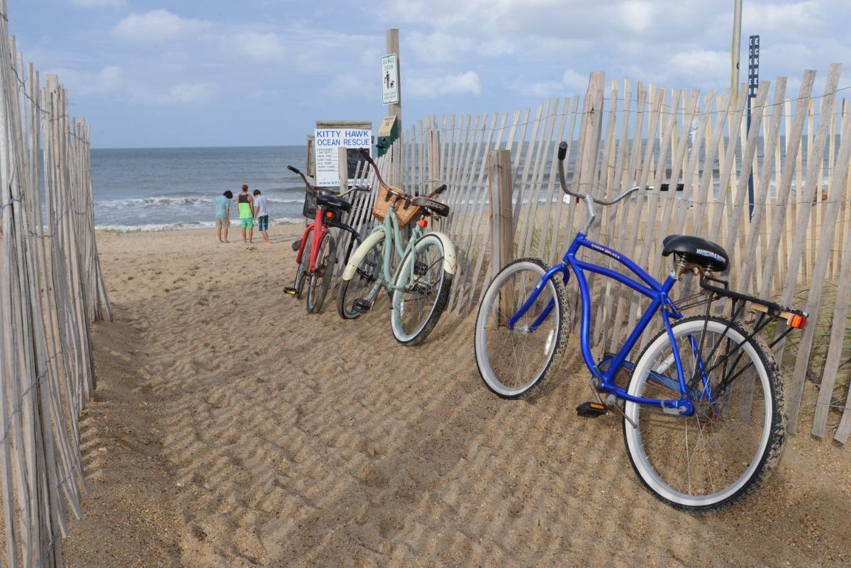 bikes sitting against a fence on the beach