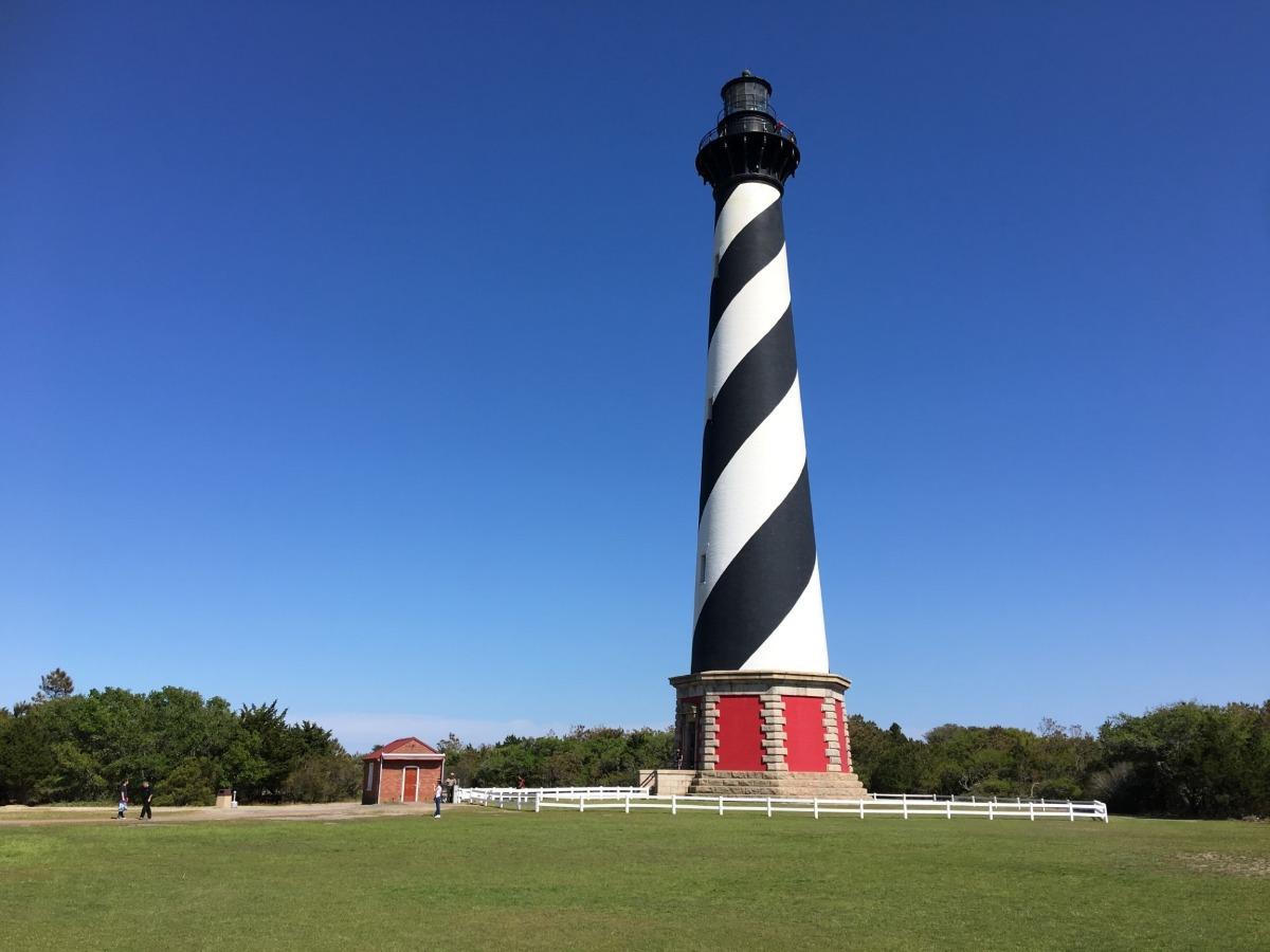 black and white sprial lighthouse on a lawn