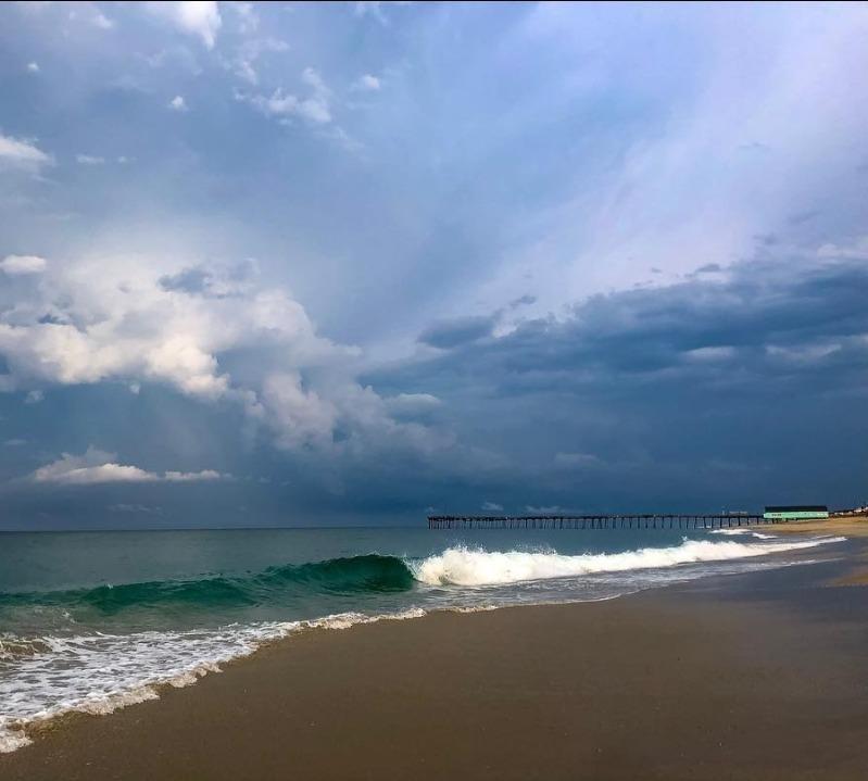 a dark stormy day looking at the ocean and pier