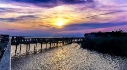 a boardwalk over the sound during sunset