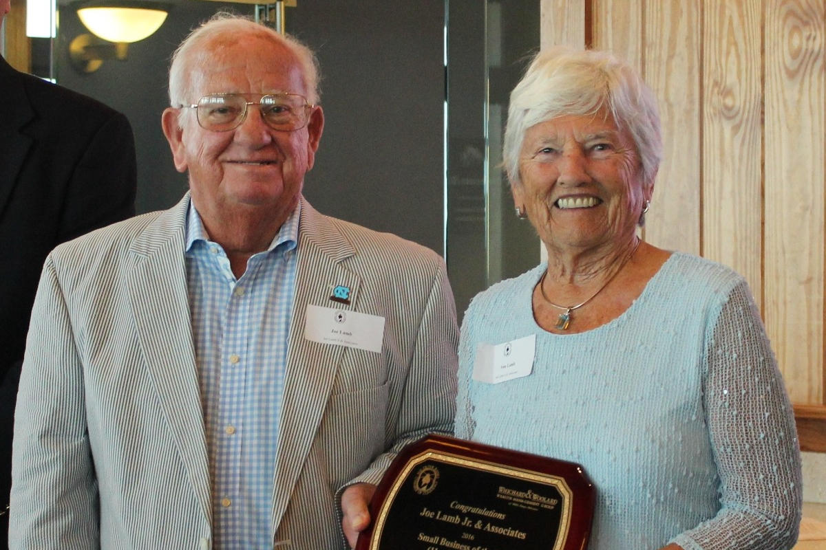 older couple holding a plaque together