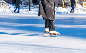 A skater gliding across a frozen pond, enjoying the beauty of winter in a peaceful outdoor setting.