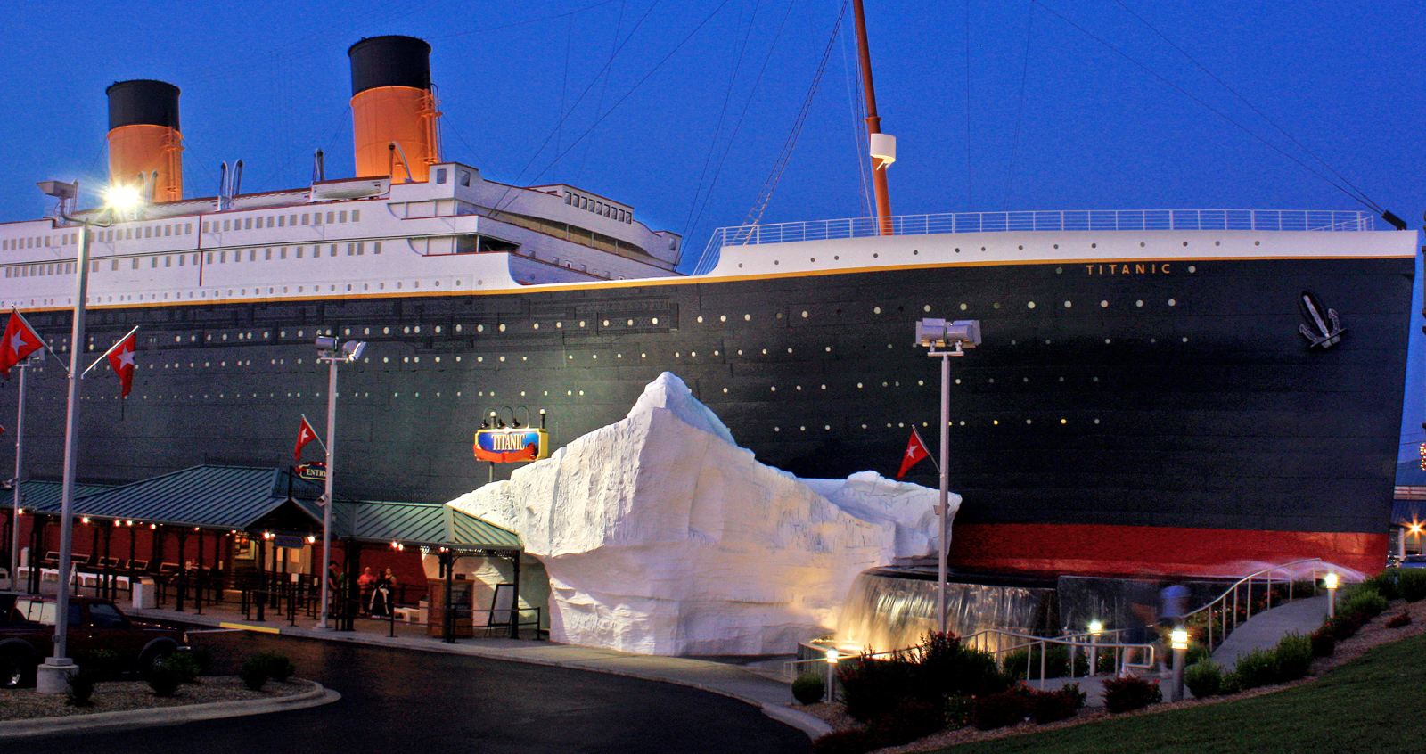 Titanic Museum Attraction in Branson at dusk, a ship-shaped building with an iceberg at the entrance, an indoor rainy day stop