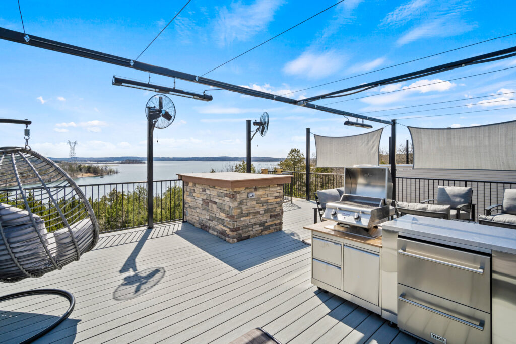 Rooftop deck at a Branson lodge rental with a stone bar, outdoor kitchen and a view across the lake