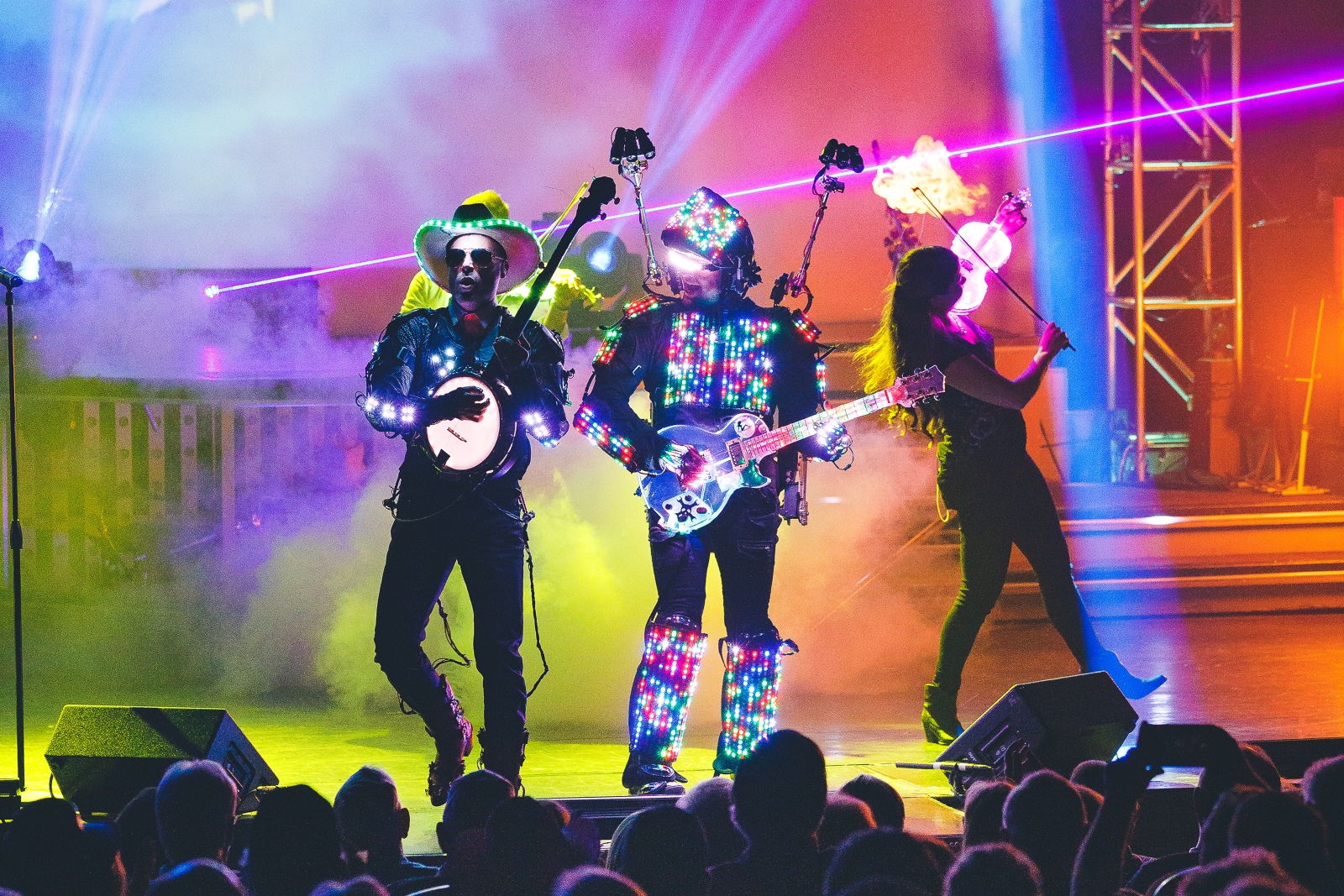 A band performs energetically on stage, illuminated by vibrant, colorful lights in Branson, MO