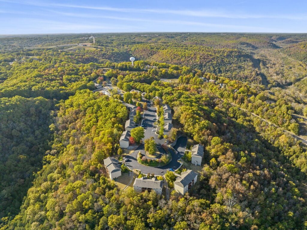 Aerial view of condo buildings in autumn woodland at a Branson West resort community