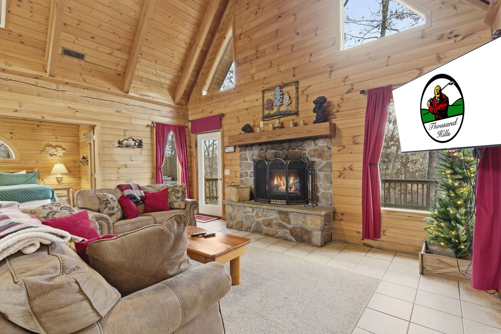 Living room with stone fireplace in a Thousand Hills Vacations cabin near Branson Cedars, about 18 miles from Silver Dollar City