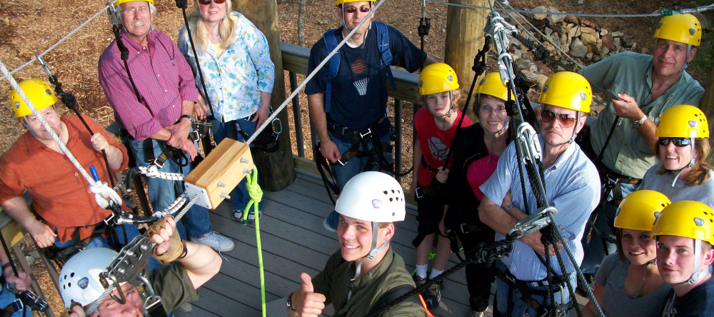 A diverse group of individuals joyfully soaring on a zipline