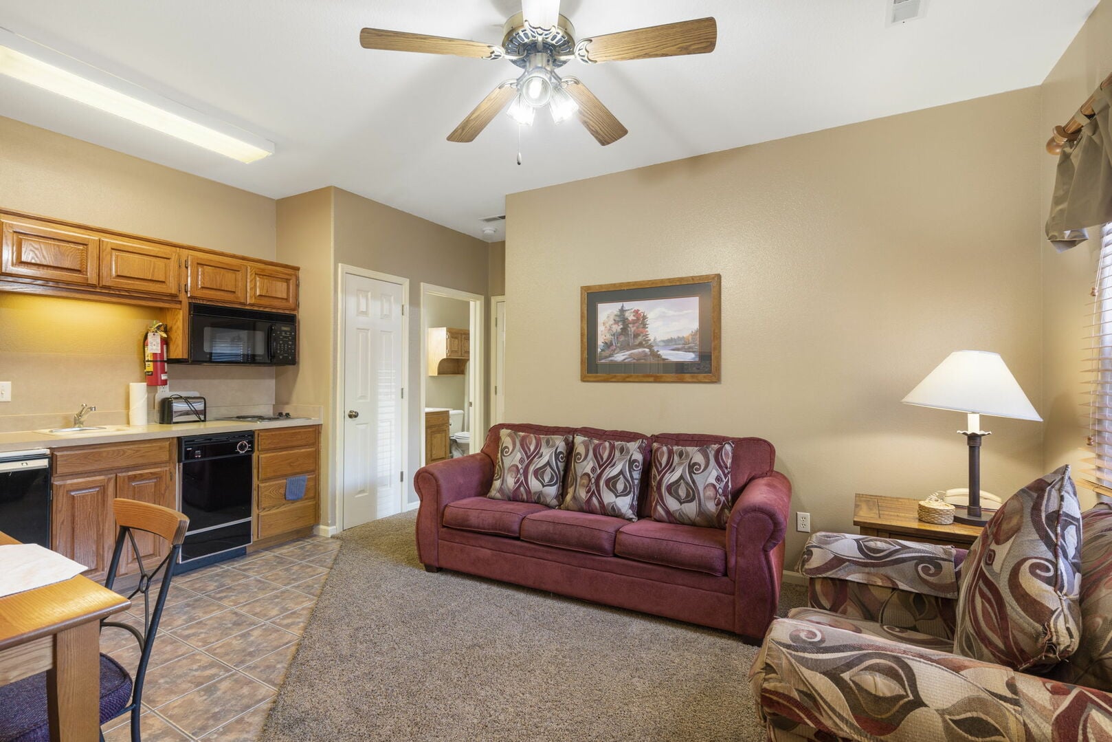 Living area with sofa, dining table, and kitchenette inside a StoneBridge Village Resort condo rental near Branson, Missouri